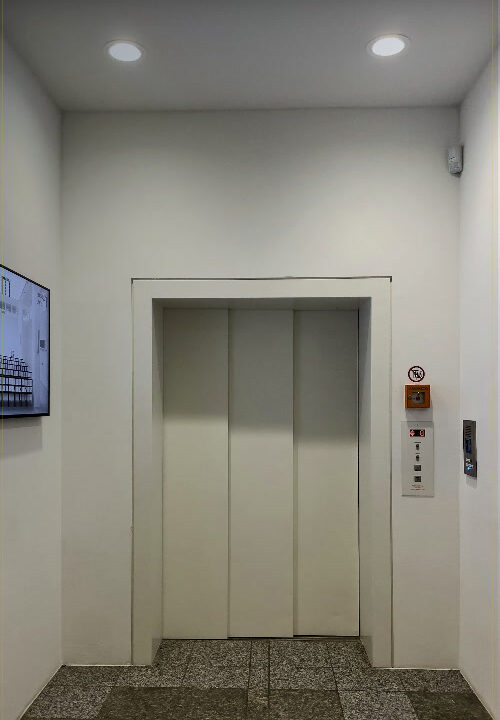 Passenger lift with closed doors in a building lobby
